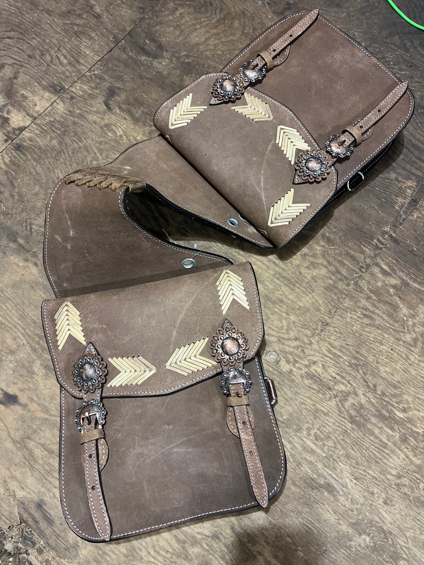 Roughout leather double saddle bag with arrow accents and fancy copper conchos and hardware